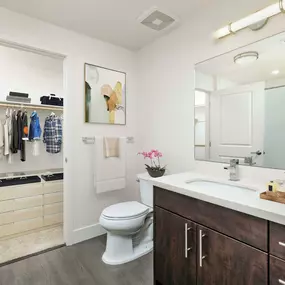 Luxury bathrooms with white quartz countertops, nickel fixtures, and ensuite walk-in closets with wooden shelves and rods