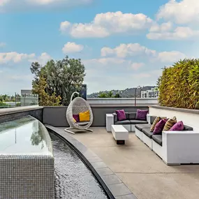 Outdoor resident lounge seating with a water feature and a view of los angeles