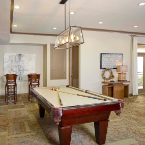 Resident game room with billiards and bar stools at Camden Plaza Apartments in Houston, TX