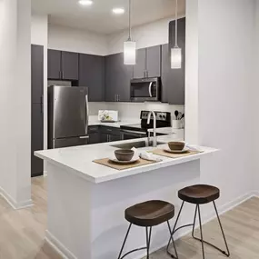 Kitchen with gray modern cabinets and white quartz countertops at Camden Plaza in Houston, TX