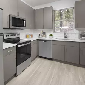 Kitchen with gray cabinets, white quartz countertops and stainless steel appliances