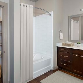 Terrace Bathroom with white quartz countertops, bathtub and shower combination, and linen closet with built-in shelving.