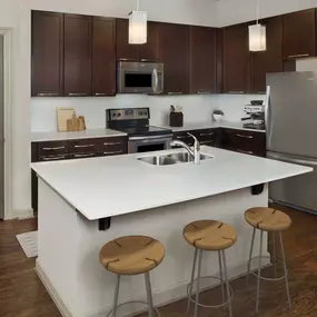 Terrace kitchen with white quartz countertops, stainless steel appliances, and hardwood-style flooring