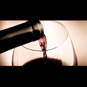 Red wine being poured into a wine glass.