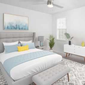 Beautifully renovated bedroom with ceiling fan with LED lighting, wood-look plank flooring throughout on first floors, and neutral carpeting in second and third floor apartment homes.