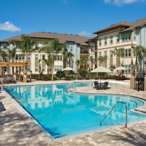 Tropical beach entry pool with cabanas and grill pavilion