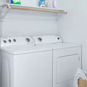 Renovated laundry room with wood shelving and rods.