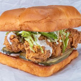 BAD MUTHA CLUCKA - two crispy fried chicken tenders, spiced to your liking (plain, nashville Hot or nashville hotter) with miso ranch, dill pickle slices and lettuce; served on kings hawaiian rolls