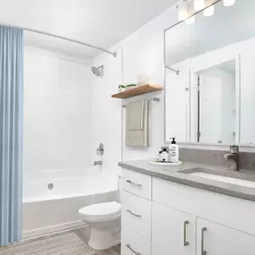 Renovated modern bathroom with gray quartz countertops and bathtub at Camden Dunwoody in Atlanta GA