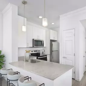 Renovated kitchen with gray quartz countertops and stainless steel appliances at Camden Dunwoody in Atlanta GA