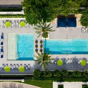 Two large pools with seating areas and beautiful landscaping