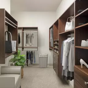 Spacious walk-in closet with wood shelving organization system at Camden Post Oak high-rise apartments in Houston, TX