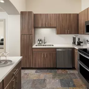 Gourmet kitchen with stainless steel appliances and quartz countertops at Camden Post Oak high-rise apartment homes in Houston, TX