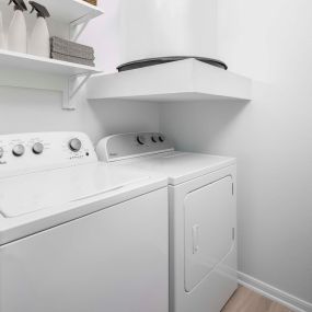 Washer and dryer with built-in laundry room shelves at Camden Panther Creek apartments in Frisco, Tx