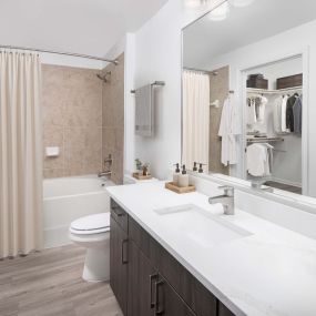 Bathroom with white quartz countertops and walk-in closet at Camden Panther Creek apartments in Frisco, TX
