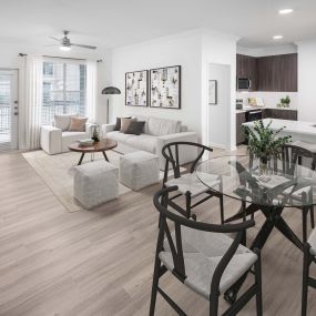 Open concept living and dining area with wood-style floors at Camden Panther Creek apartments in Frisco, TX