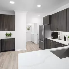 Spacious kitchen with white quartz countertops and laundry room at Camden Panther Creek apartments in Frisco, TX