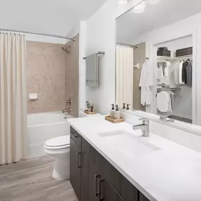 Bathroom with white quartz countertops and walk-in closet at Camden Panther Creek apartments in Frisco, TX