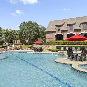 Resort-style pool with poolside deck chairs and fountains at Camden Panther Creek in Frisco, TX