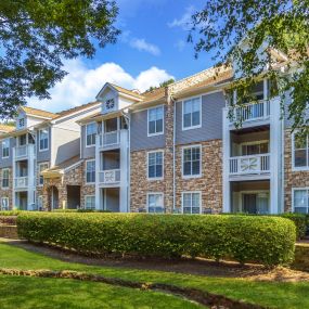 Building exterior surrounded by large trees at Camden Sedgebrook in Huntersville, NC