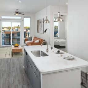 Kitchen with large islands, pendant lighting, white upper and gray lower cabinets