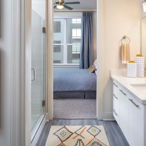 Bathroom with glass-enclosed shower and quartz countertops