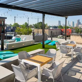 Rooftop Lounge with dining areas, corn hole, and city views