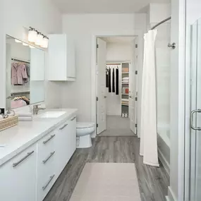 Luxury Ensuite Bathroom with double vanity, large soaking tub, stand up shower, and walk-in closet