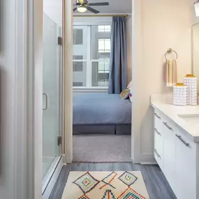 Bathroom with glass-enclosed shower and quartz countertops