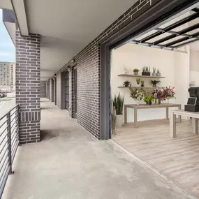 Live/work apartment staged as a plant shop with side walk entrance and open glass paneled garage door at Camden RiNo Apartments in Denver, CO