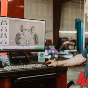 Auto mechanic performing an alignment service on a vehicle