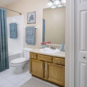 Bathroom with curved shower rod and LED vanity lighting.