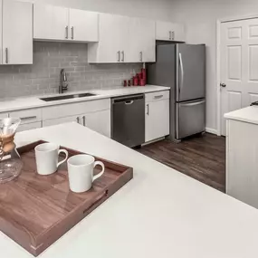 Kitchen with quartz countertops stainless steel appliances gas cooktop and wood look flooring