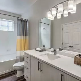 Bathroom with quartz countertops garden bathtub with natural light and wood look flooring