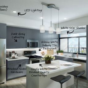 Dark grey finishes in open concept kitchen with quartz countertops and pendant lighting.