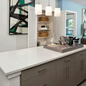 The A2 floor plan features an open kitchen, chic pendant lighting, a large pantry, and a kitchen island with a quartz countertop at Camden Lake Eola apartments in Orlando, FL