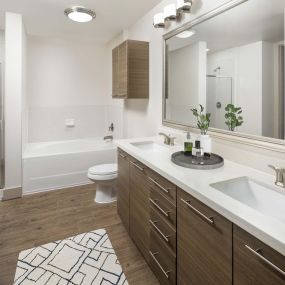 Modern style bathroom with quartz countertops, garden tub, and stand-alone shower at Camden City Centre Apartments in Houston, TX.