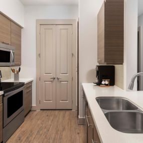 Modern style kitchen with quartz countertops and stainless appliances at Camden City Centre Apartments in Houston, TX.