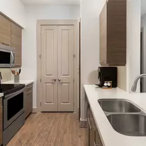 Modern style kitchen with quartz countertops and stainless appliances at Camden City Centre Apartments in Houston, TX.