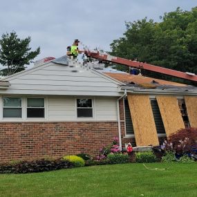 Shingles being loaded on a roof that is partially stripped