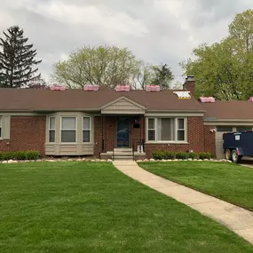 Roof loaded with shingles and a trailer in the driveway. This roof is ready to be stripped and re-shingled