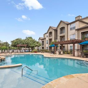 Apartment homes and private balconies overlooking resort-style pool and sundeck at Camden Amber Oaks apartments in Austin, TX
