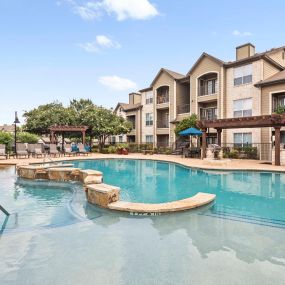 Resort-style pool with tanning ledge at Camden Amber Oaks apartments in Austin, TX