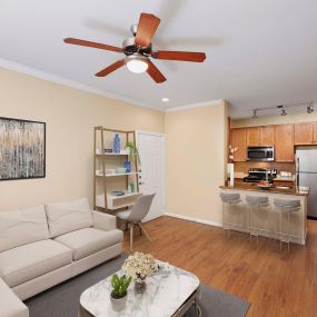 Living room with work from home space white crown molding and ceiling fan