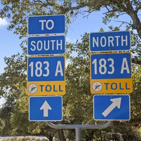 Highway 183 and toll road signs near Camden Brushy Creek apartments in Cedar Park, TX