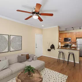 Living and kitchen with wood-style floors at Camden Amber Oaks apartments in Austin, TX