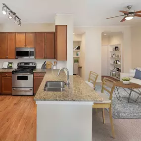 Kitchen and carpeted living room with desk and built-in shelves at Camden Amber Oaks