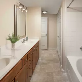 Bathroom with two sinks and bathtub at Camden Amber Oaks