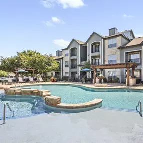 Resort-style pool with tanning ledge at Camden Amber Oaks apartments in Austin, TX