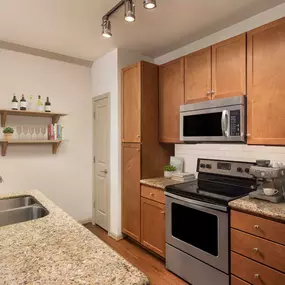 Kitchen with white subway-tile backsplash and granite countertops at Camden Amber Oaks